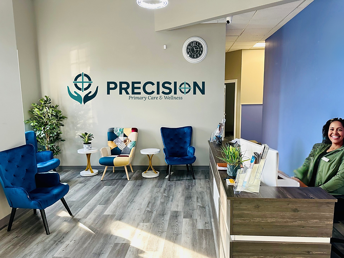 Smiling receptionist at modern PRECISION Primary Care & Wellness reception area.
