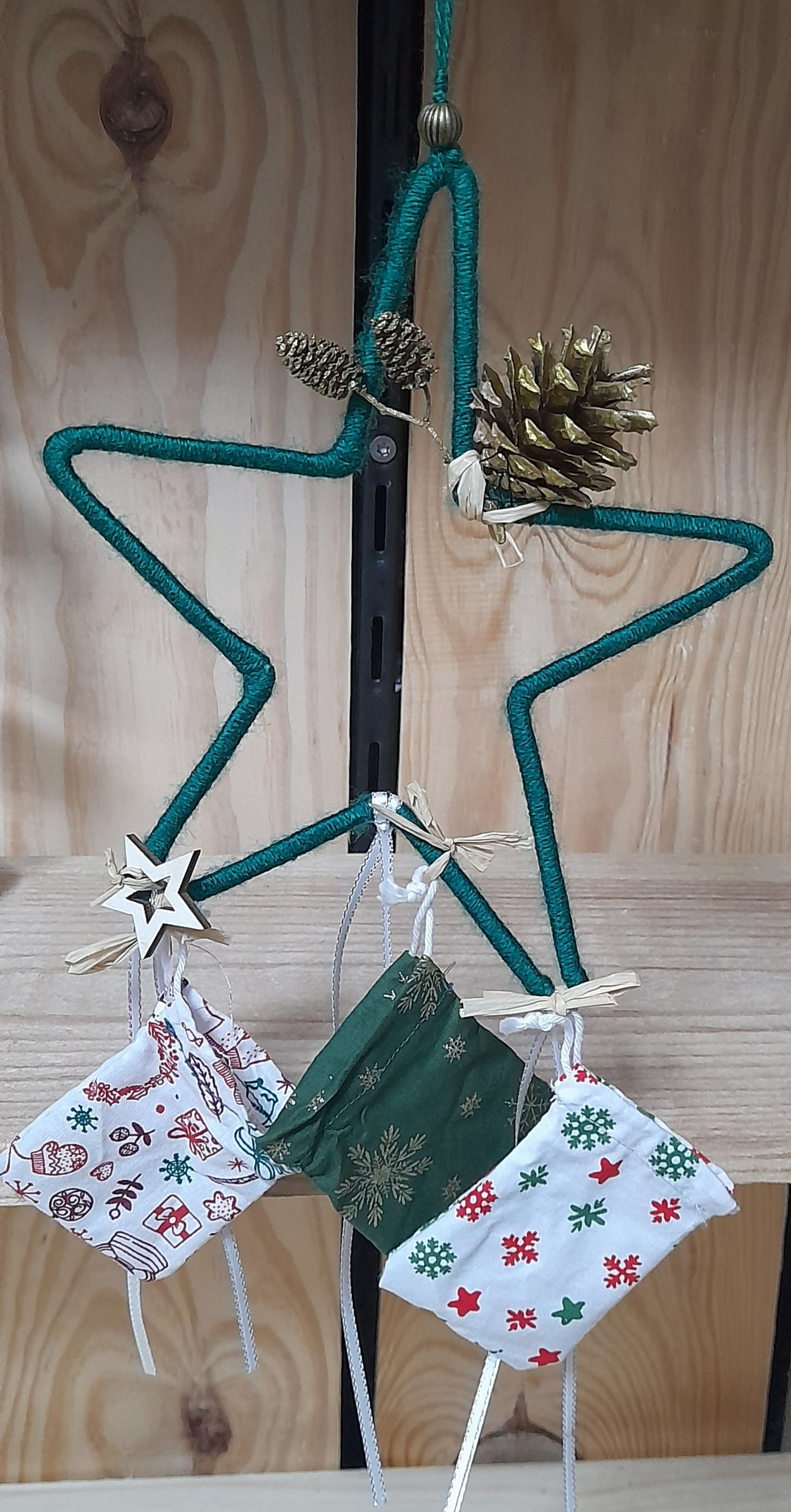 un grande étoile avec 3 petits pochons thème noël et une décoration nature 