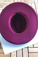 Thumbnail: Wine Wide Brim Fedora, inside view, on white paper, wooden surface background.