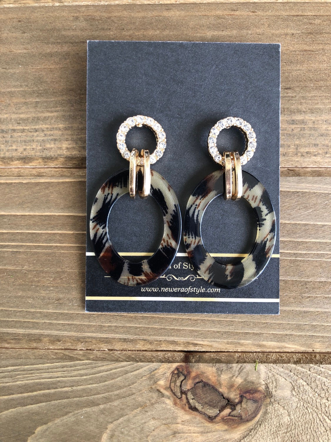Pair of patterned hoop earrings. Website address is shown on black card.