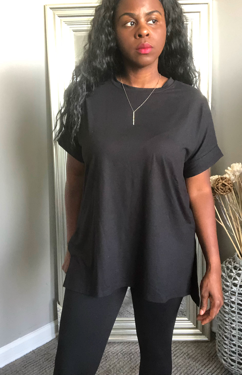 Thumbnail: Woman wearing a black oversized shirt and necklace. Simple outfit indoors.