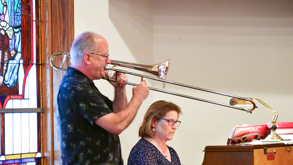 man playing trombone and woman playing piano