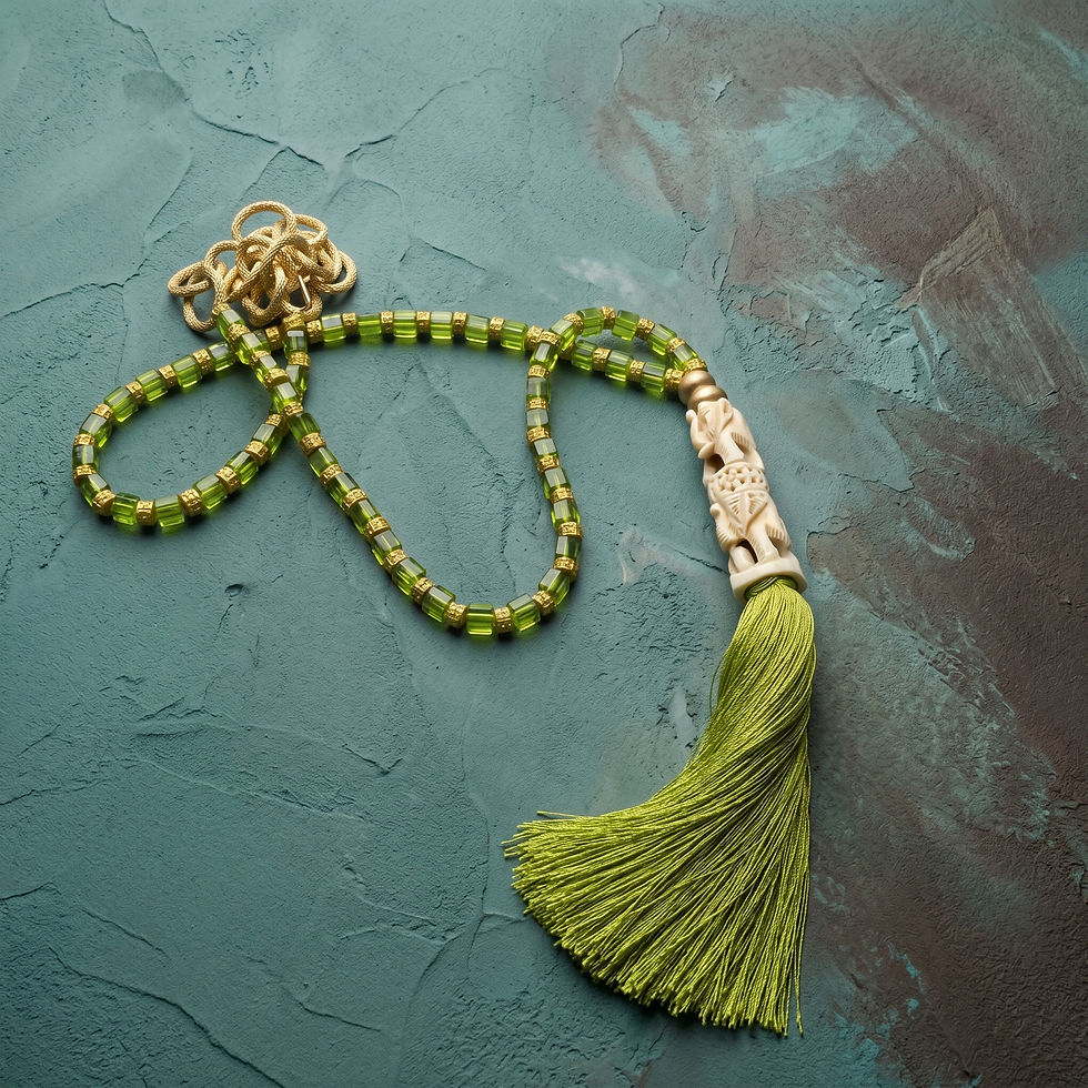 Green beaded tassel necklace with carved focal bead by MHL Jewelry Designs.