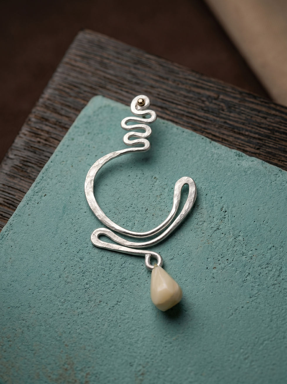 Hammered silver drop earring with a dangling stone charm by MHL Jewelry Designs.