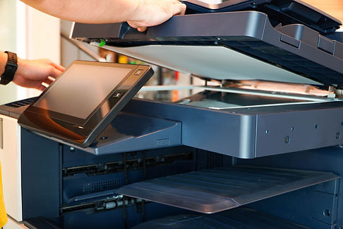 Men press the button of the copier. Man copying paper from Photocopier. Men use printing m