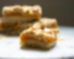 An apricot bar with double fruit filling and almonds on top.