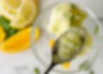 A spoon of Citrus Basil sorbet with slices of orange, lemon and basil.