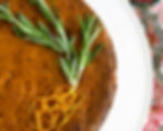 Overhead shot of olive oil cake with orange zest and rosemary sprigs