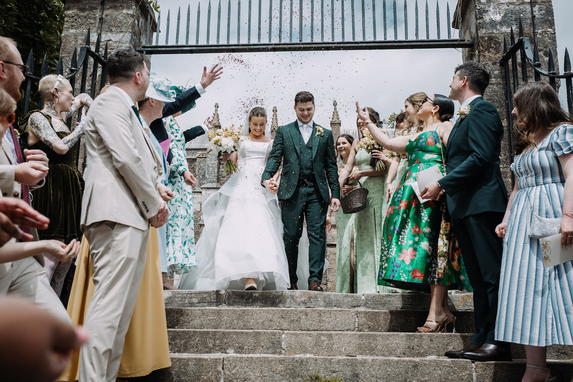 Bride and groom smiling as confetti rains down
