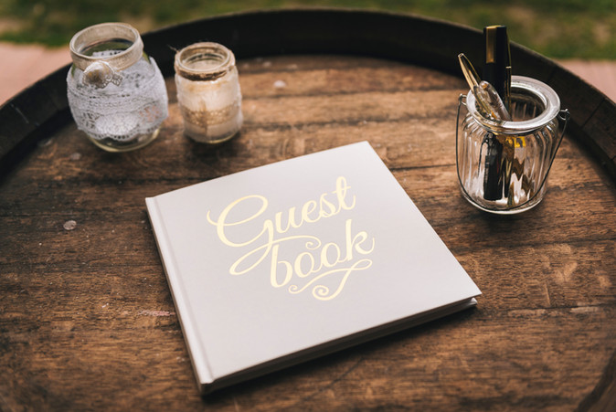 Close-up of a wedding guest book displayed on a wooden barrel