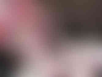 A glass jar with pink and white mini marshmallows spilling onto a dark surface, tied with a red gingham ribbon