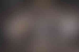 An acoustic duo performing inside a rustic wedding venue, with one musician playing guitar and the other singing