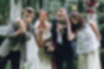 Wedding guests smiling and posing while holding photobooth props