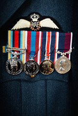 Close-up of military medals pinned to a dark dress uniform beneath a Royal Air Force pilot wings badge