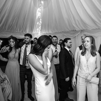 A bride reacts with emotion while guests watch closely during a live performance