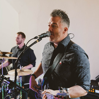 A male singer/guitarist performing for guests at a wedding reception