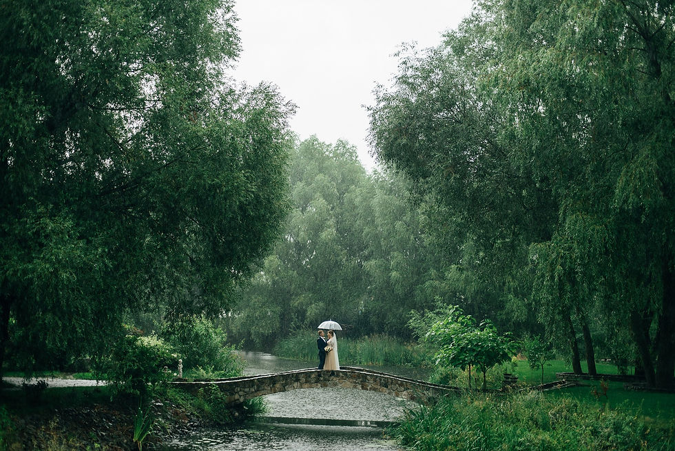 A couple pictured in the rain on their wedding day