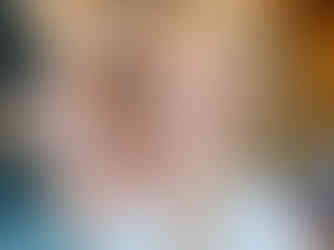 A bride having her makeup applied before the ceremony, with soft pink eyeshadow and elegant curls