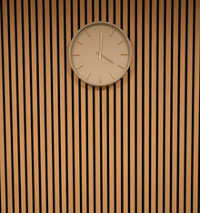 Decorative and acoustic wood panel wall with green clock in Consultation Room 5 Upstairs at Rosewood Clinic