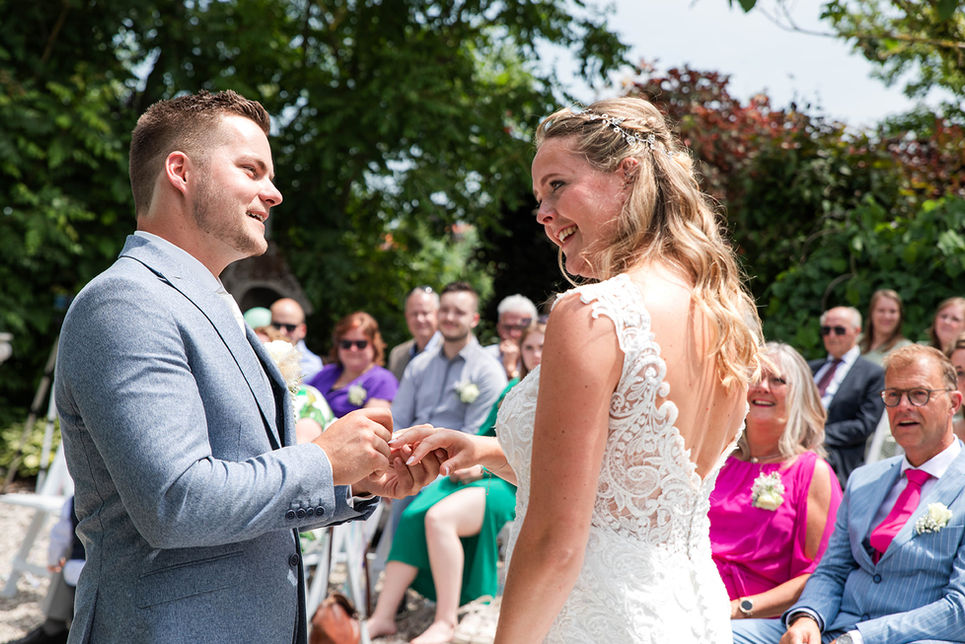 Man schuift ring over vinger bruid