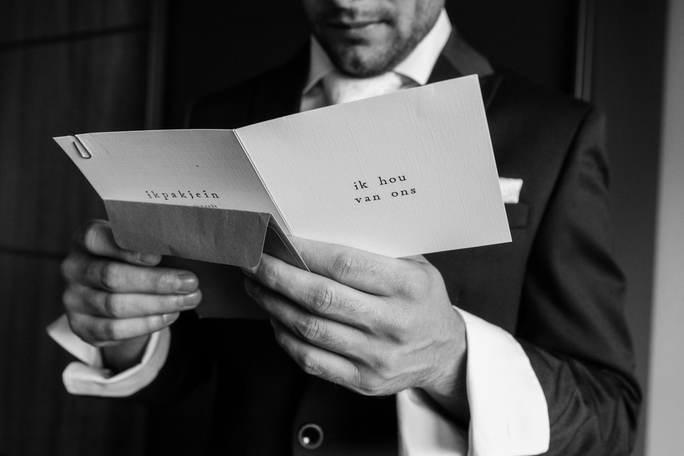 Bruidegom leest kaart voor fotoshoot