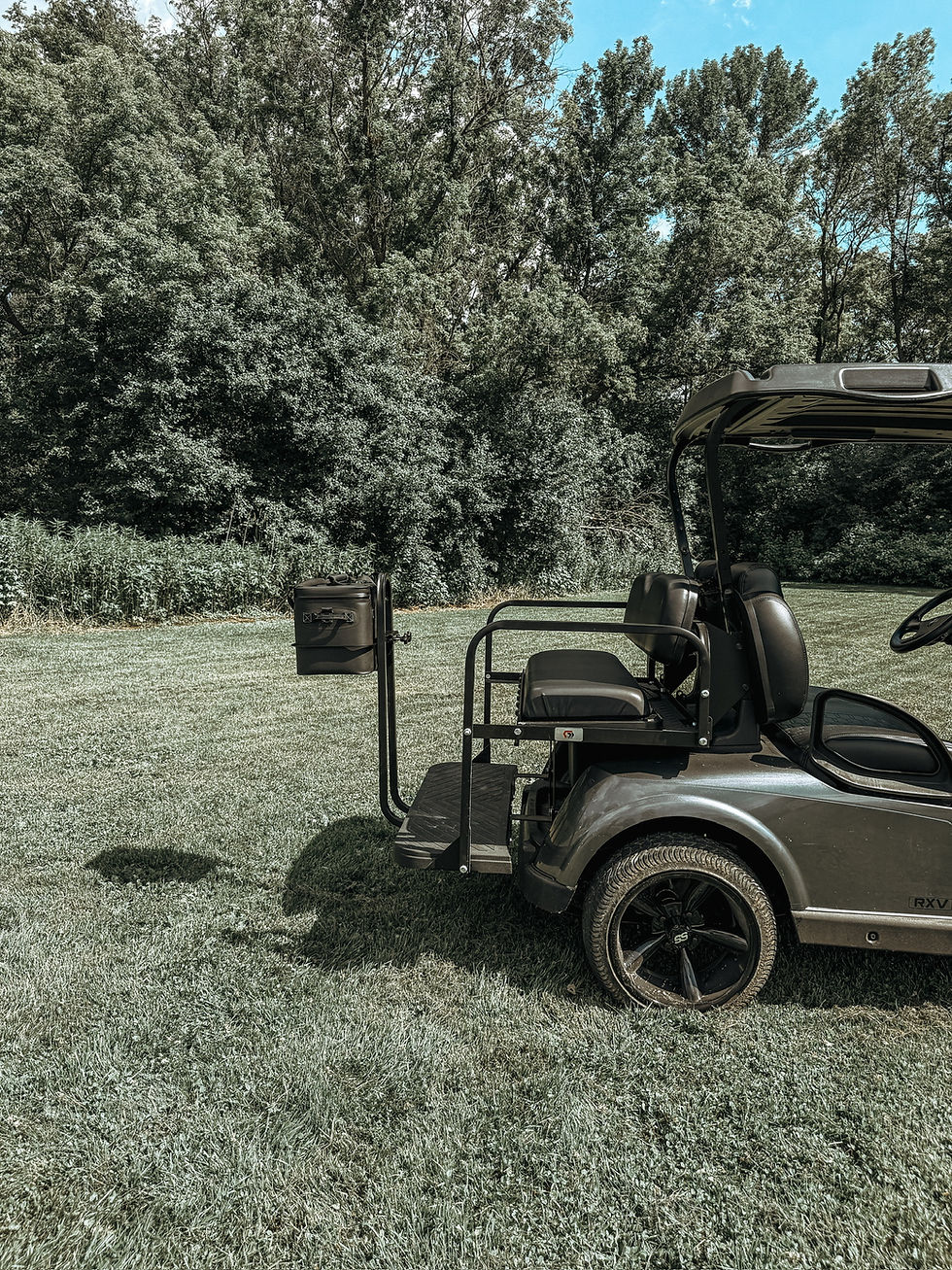 Thumbnail: RTIC soft cooler mounted on the rear grab bar of a golf cart using the Cooler Caddie bracket, passenger side view.
