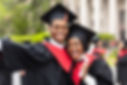 Happy african american couple students in graduation dresses and hats taking selfie togeth