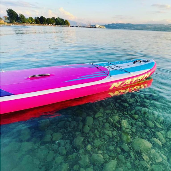 Ein Stand-up-Paddleboard in Pink, schwimmend auf dem kristallklaren Bodensee-Wasser.