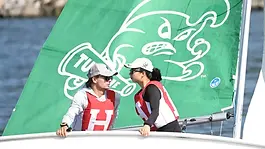 Callahan climbs to the high side of the boat to flatten a roll tack at the 2026 College Sailing Open Team Race Nationals 