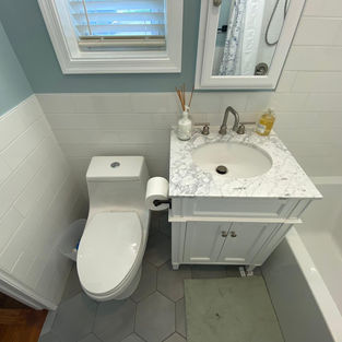 White shaker vanity with marble-style top and new framed mirror