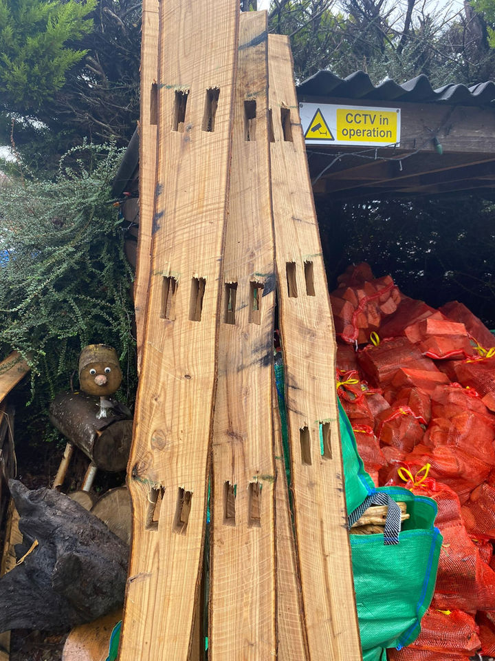 Wooden planks with rectangular cuts, warning sign, and chopped wood background.