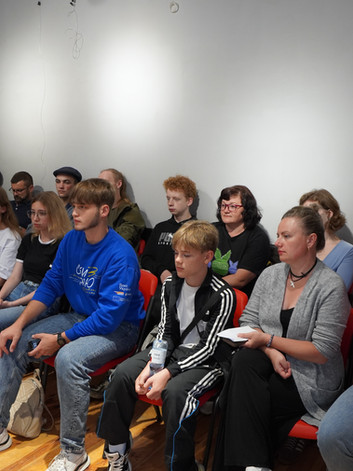 Група людей уважно слухає на тренінгу у кімнаті.