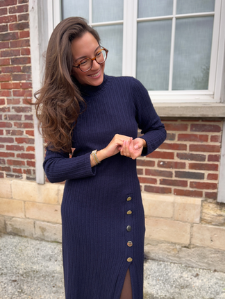 femme brune debout avec robe en maille bleue marine