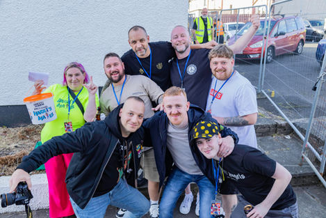 Group of 8 friends smiling and posing at an outdoor event