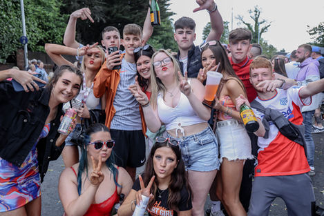 Smiling young people making hand gestures at an event