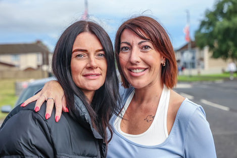 Two women smiling at an outdoor event