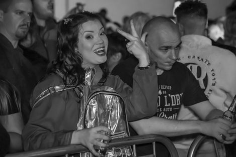 Smiling woman pointing in a crowd at an event