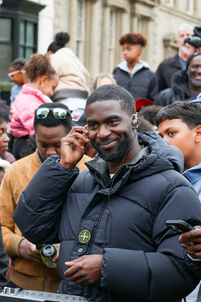 Smiling bearded man with earbud at outdoor event