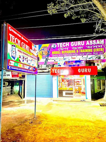 Front view of TechGuru Assam mobile repair and training center, showcasing the shop signage at night.