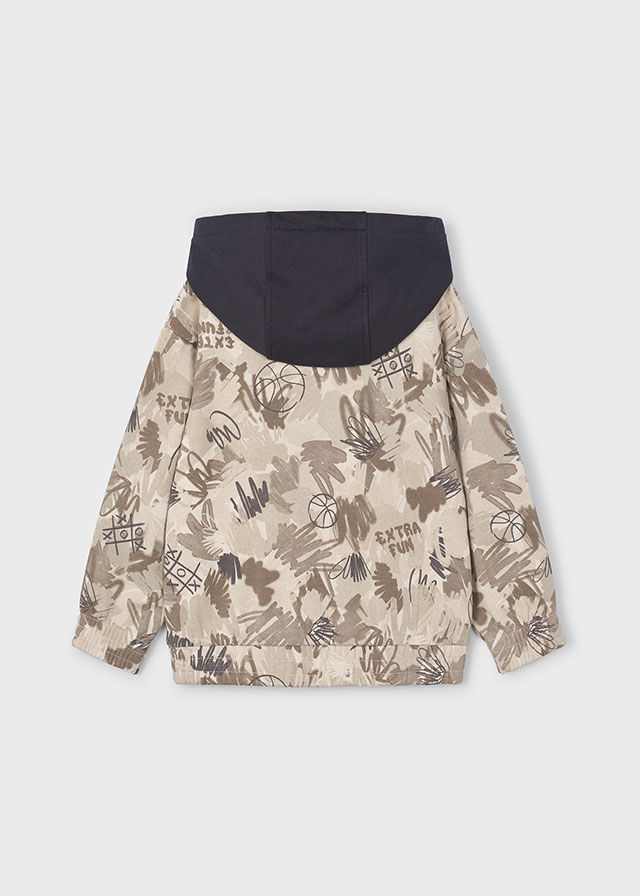 Beige gemusterte Wendejacke für Kinder mit dunkelblauer Kapuze.
