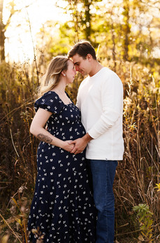 lovely couple posed for a maternity picture during sunset in a lovely field of tall grass, Noblesville indiana maternity photographer