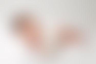 newborn baby girl in side laying pose on white background for professional newborn session portrait