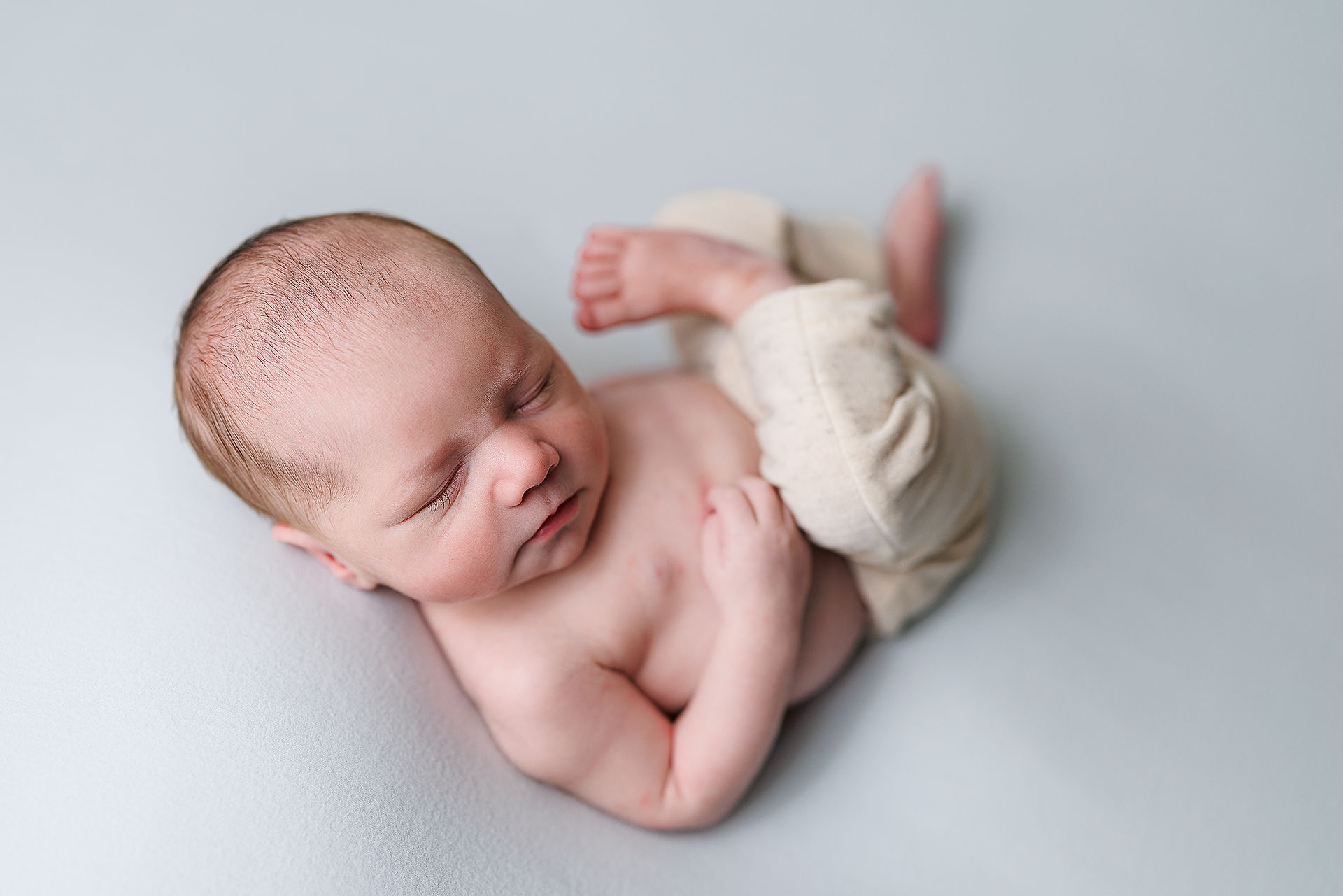 newborn posing, newborn session, newborn photography, potato sack pose, newborn wrapped poses, newborn photographer near me, newborn side laying pose, newborn boy on blue, newborn huckfin pose
