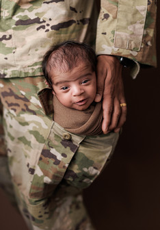 newborn baby boy in dads military army pants pocket