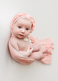 noblesville newborn photographer, fishers newborn photographer, westfield newborn photographer, newborn photographer near me, newborn portrait photographer,  huckfin pose, egg wrap pose, newborn in bonnet looking at camera 