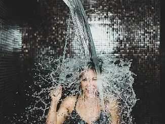 woman-taking-a-cold-shower-from-ice-bucket-2022-12-22-20-05-54-utc-1-scaled.webp