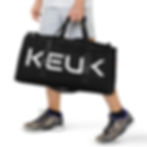 Person carrying large KEUK black duffel bag