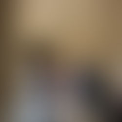 People walk through a grand hallway with statues, arched ceilings, and checkerboard floor.