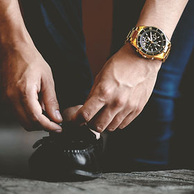 Man with Watch Tying His Shoes