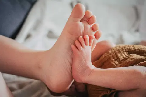Babyfüsse von Geschwistern die sich berühren.